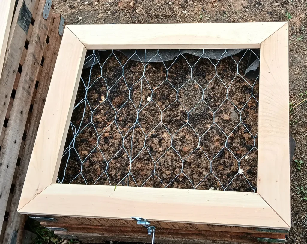 Horse herb garden planter with wooden frame and chicken wire lid to protect plants from horses